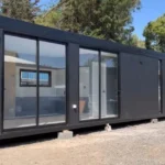 Casa modulare Montes 12 x 3 m – 36 m² siding verticale nero con interni bicolore grigio - immagine 1