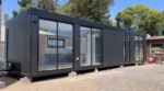 Casa modulare Montes 12 x 3 m – 36 m² siding verticale nero con interni bicolore grigio - immagine 1