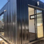 Casetta modulare Nogal 18 m² – lamiera acero nero con ampie vetrate in alluminio - immagine 1