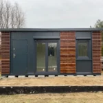 Container Abitabile 6 x 3 m — Pannelli Antracite con Rivestimento in Legno Mogano Orizzontale e Porta-Finestra Vetrata - immagine 1