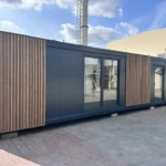 Container Ufficio 36 m² (12 x 3 m) — Rivestimento Bimateria Antracite e Listoni Legno Verticali - immagine 1