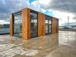 Container Ufficio 7 x 3 m — Listoni in Legno Naturale Verticali e Vetrate Panoramiche Antracite - immagine 4