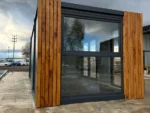 Container Ufficio 7 x 3 m — Listoni in Legno Naturale Verticali e Vetrate Panoramiche Antracite - immagine 7