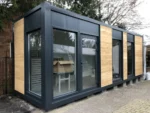 Container Ufficio 8 x 3 m — Facciata Grigia con Tre Fasce di Legno Orizzontale e Vetrate - immagine 2