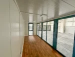 Container Ufficio Modello Falcón 2,4 x 6,0 m — Facciata con Vetrate a Tutta Altezza in Alluminio Verde/Teal e Pannelli Bianchi - immagine 4