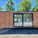 Modulo Abitabile 14 m² — Rivestimento Totale in Listoni Verticali di Pino Naturale con Grande Porta Scorrevole Antracite - immagine 1