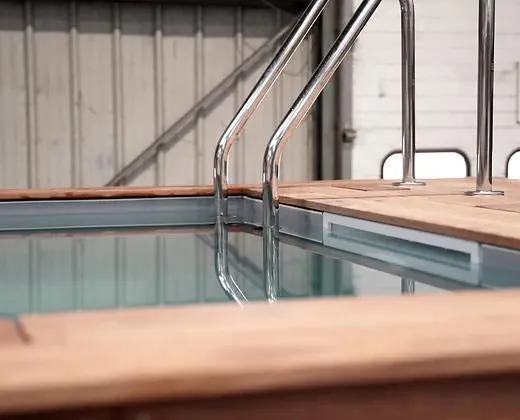 Piscina container 20 piedi nera con bordo in legno e scala inox - immagine 2