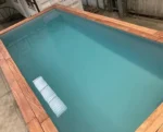 Piscina container 20 piedi nera con bordo in legno e scala inox - immagine 3