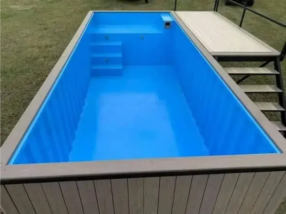 Piscina container rialzata 6 m con terrazza solarium integrata, rivestimento WPC grigio e vasca blu - immagine 2