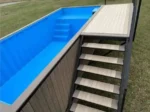 Piscina container rialzata 6 m con terrazza solarium integrata, rivestimento WPC grigio e vasca blu - immagine 3