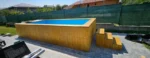 Piscina in legno 6,8 × 2,4 m con stufa a legna integrata, liner blu e scala laterale - immagine 1