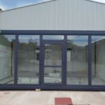 Ufficio Modulare 20 Piedi (6,0 x 2,4 m) — Facciata Completamente Vetrata in Alluminio Antracite con Porta a Quattro Pannelli - immagine 1
